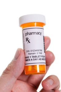 A doctor holds up a bottle of prescription medications as he explains why his patient may need a prescription drug addiction treatment program in UT