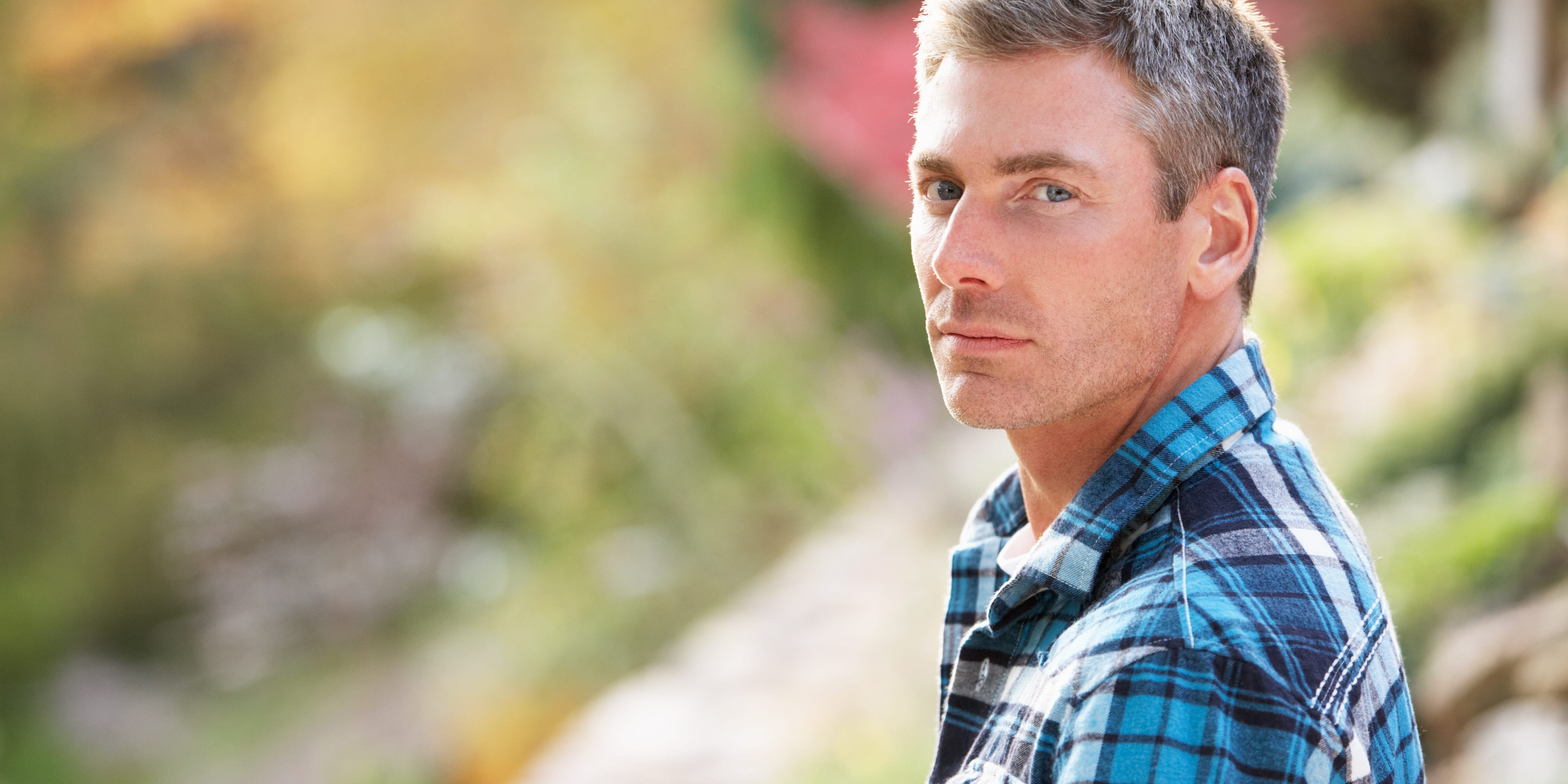 Portrait Of Man Standing Outside In Autumn Landscape A man stands outside and thinks about how addiction can change your personality