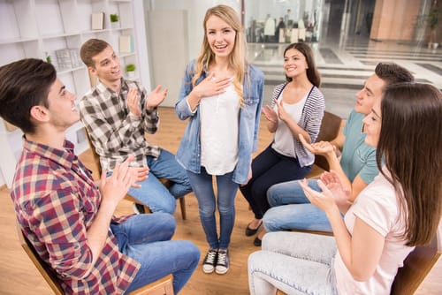 A woman stands up and announces that she is committing to the group's recovery