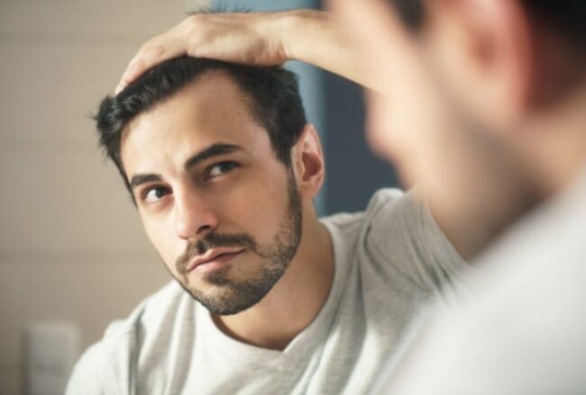 A man smooths his hair back and wonders how does leaving your comfort zone improve addiction recovery