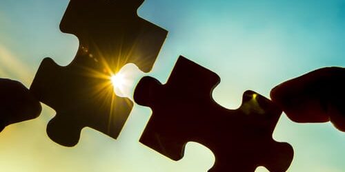 Two puzzle pieces are held up to the sky, as the people holding them discuss how the SUPPORT act protects people seeking addiction treatment