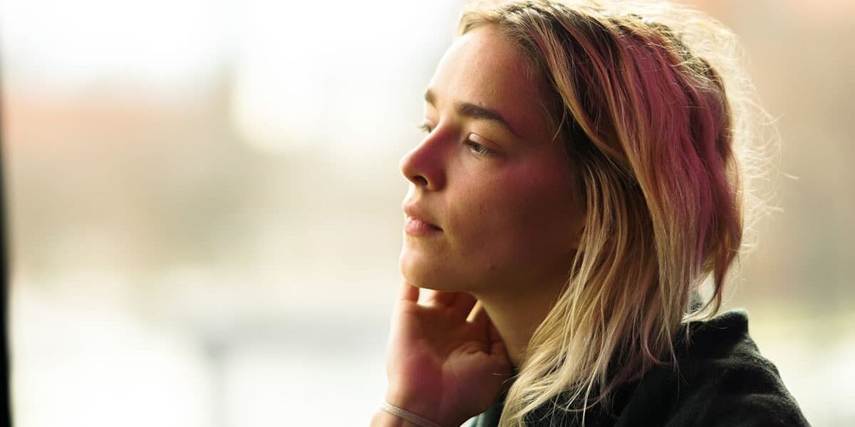 A woman stares out into the distance, wondering "Is marijuana a gateway drug?"
