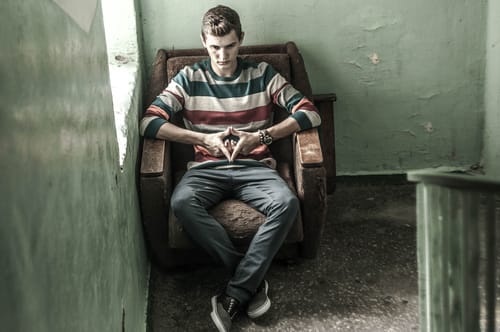 A young man sits in a dilapidated chair and wonders what are the most dangerous drug combinations