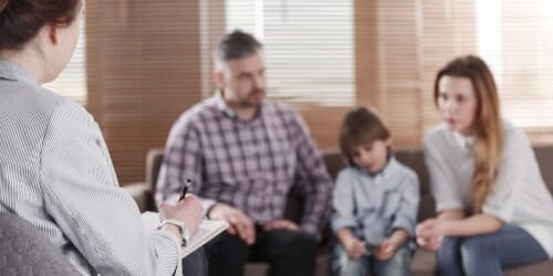 shutterstock_1099813580 a therapist talks to a family about why family therapy is so important for addiction recovery