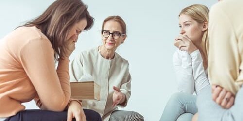 a woman cries as she talks to a group about how depression affects your decision making