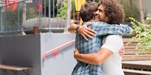 a man hugs his friend and thinks about how kindness can help you beat depression