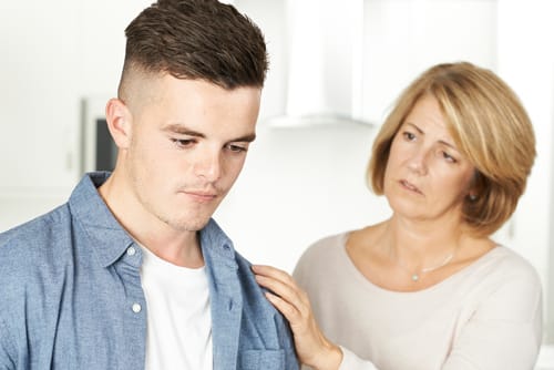a mother comforts her teen as she notices signs of anxiety disorders in teens