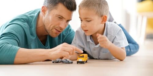 a man plays with his son and thinks about ways your drinking might affect your kids