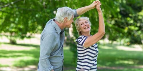 an older man and woman dance as they avoid addiction in older populations