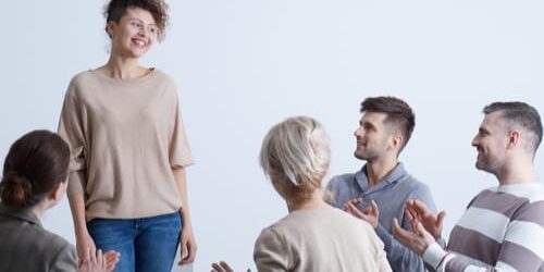 shutterstock_646781653 a woman talks to a group about replacement addictions to watch out for