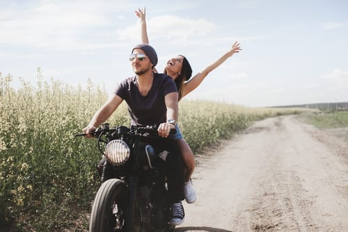 a man and woman ride a motorcycle down a dusty road as they go through the process of self discovery