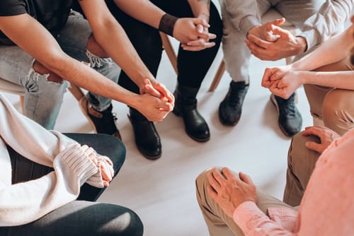 a group of people talk about 5 benefits of group therapy