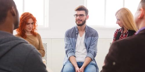 shutterstock_732481252 a man talks to a group about how to make better decisions even if youre depressed