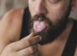A man puts an edible hallucinogen on his tongue and wonders what is a hallucinogen