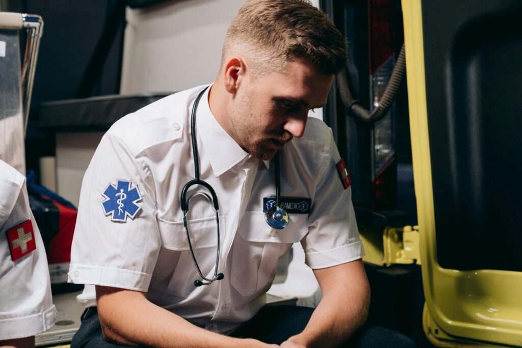 An EMT sitting in the back of an ambulance