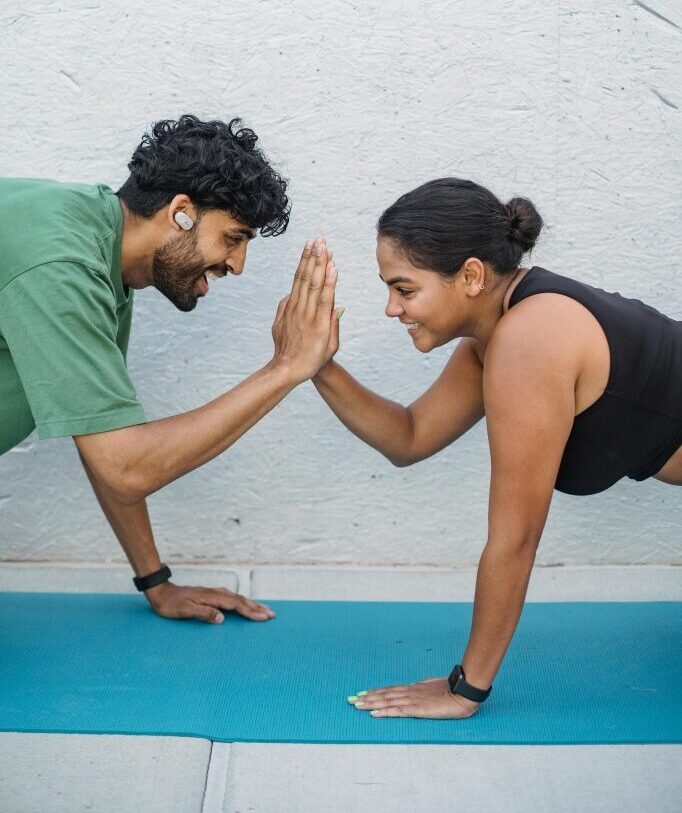 Two people high fiving during a yoga session