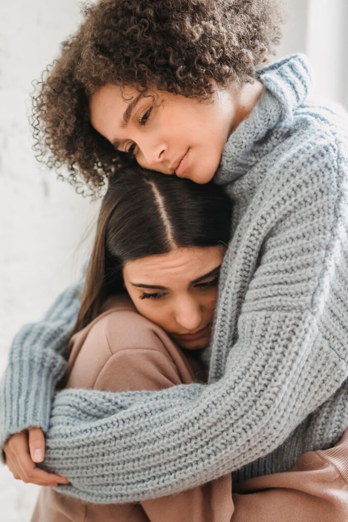 Two women in sweaters hugging